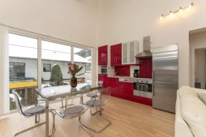 eine Küche mit roten Schränken, einem Glastisch und Stühlen in der Unterkunft Appartement Göbel by Schladming Appartements in Haus im Ennstal