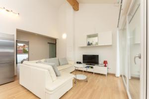 ein weißes Wohnzimmer mit einem weißen Sofa und einem TV in der Unterkunft Appartement Göbel by Schladming Appartements in Haus im Ennstal