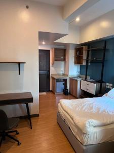 a bedroom with a bed and a desk and a kitchen at iSulates Malate 乔布斯公寓酒店 in Manila