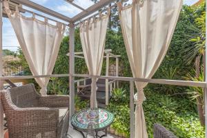 a patio with curtains and a table and chairs at Villas D. Dinis - Charming Residence (adults only) in Lagos