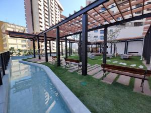 - un bâtiment avec des bancs et une piscine dans l'établissement 2403 apartamento Setor Oeste gyn, à Goiânia