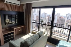 - un salon avec un canapé et une grande fenêtre dans l'établissement 2403 apartamento Setor Oeste gyn, à Goiânia