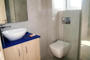 La salle de bains est pourvue d'un lavabo, de toilettes et d'une douche. dans l'établissement Stone Bay Houses in Messinia Kalamaki Beach Area, à Chrani