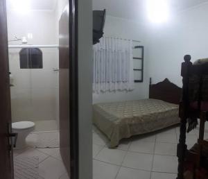 a bedroom with a bed and a bathroom with a shower at Casa confortável com 4 suítes para até 20 pessoas. in Itanhaém +10 photos