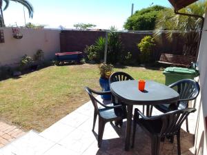 einen Tisch und Stühle auf einer Terrasse in der Unterkunft Raiden's Home in Saldanha