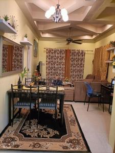a living room with a table and chairs and a couch at Regina Vacation House in Tayud