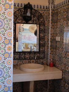 uma casa de banho com um lavatório e um espelho em Panorama chez Hamid em Rissani