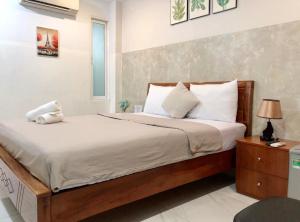 1 dormitorio con 1 cama grande con almohadas blancas en Saigon Cozy Hotel en Ho Chi Minh