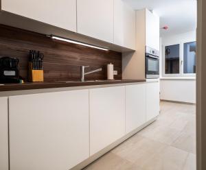 a kitchen with white cabinets and a sink at Zoder Apartments in Vienna