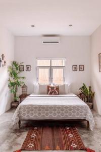 ein Schlafzimmer mit einem großen Bett in einem weißen Zimmer in der Unterkunft Gorgeous Colorful & Tropical Villa Canggu - VYG in Canggu