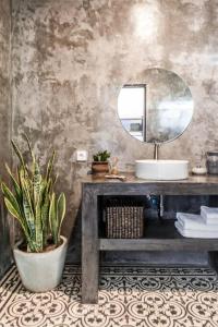 een badkamer met een wastafel, een spiegel en een potplant bij Gorgeous Colorful & Tropical Villa Canggu - VYG in Canggu