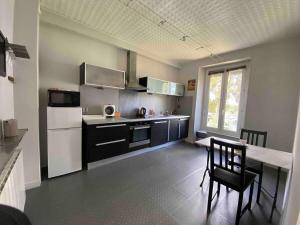een keuken met een aanrecht, een tafel en een koelkast bij Casa Blancheraie in Angers
