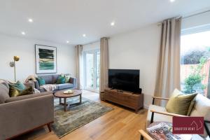 sala de estar con sofá y TV en Woking - 3 Bedroom House - With Garden, en Chobham