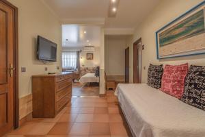 a bedroom with a bed and a flat screen tv at Villas D. Dinis - Charming Residence (adults only) in Lagos