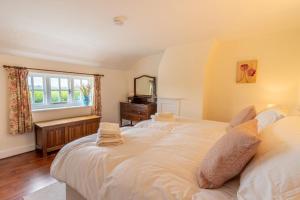 a bedroom with two beds and a window at 4 Church Cottages in Reydon