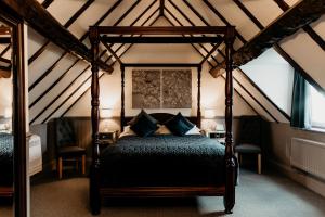 a bedroom with a canopy bed in a attic at Oak Farm Hotel in Cannock