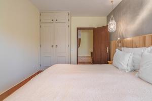 a bedroom with a large bed with white pillows at Villas D. Dinis - Charming Residence (adults only) in Lagos