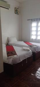 twee bedden naast elkaar in een kamer bij Syvongsack Guesthouse in Pakbeng