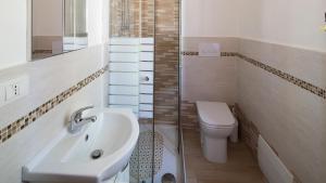 a bathroom with a sink and a toilet and a shower at Appartamenti Agrustos in Budoni