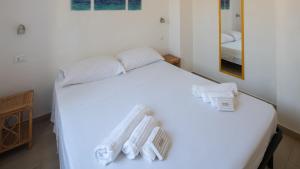 a bedroom with a white bed with towels on it at Appartamenti Agrustos in Budoni