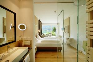 a hotel room with a bed and a bathroom at Amerika-Holzer Hotel & Resort in Sankt Kanzian +48 photos