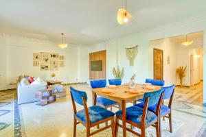 開羅的住宿－The Garden Suites near CFC by ELEGANT，一间带桌子和蓝色椅子的用餐室