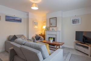 a living room with a couch and a tv at Albany Cottage in Southwold