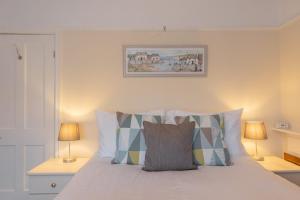 a bedroom with a bed with pillows and two lamps at Albany Cottage in Southwold