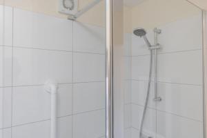 a shower with a shower head in a bathroom at Albany Cottage in Southwold +19 photos