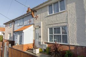 a gray house with a white door and windows at Albany Cottage in Southwold