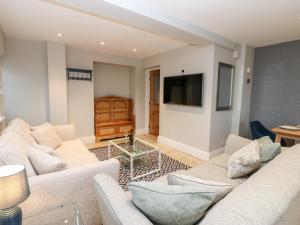 a living room with two white couches and a flat screen tv at Ravenside in Hexham