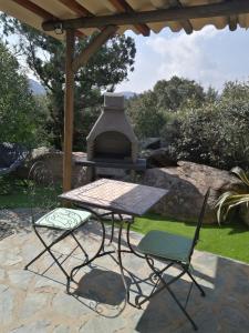 un tavolo da picnic e 2 sedie di fronte a un grill di Studio de charme à 300 m de la Plage de Santa Giulia a Porto Vecchio