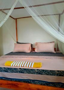 a bed in a tent with two pillows on it at Zahra Homes in Mombasa