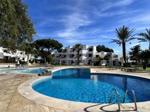 una piscina in un resort con edifici sullo sfondo di Albufeira Balaia Golf Village 4 With Pool by Homing ad Albufeira