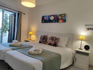 two beds in a bedroom with towels on them at Albufeira Balaia Golf Vilage 4 With Pool by Homing in Albufeira +35 photos