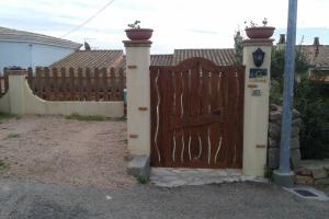 una puerta de madera frente a una valla en Meraviglioso appartamento sul porto en Santa Maria Navarrese