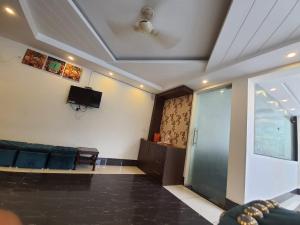 a living room with a couch and a tv at New Gokul Grand in Dehradun