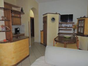 cocina con mesa y cocina con nevera en Meraviglioso appartamento sul porto, en Santa Maria Navarrese