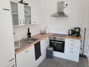 a small kitchen with white cabinets and a sink at holiday home eva in Worms