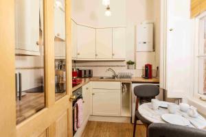 una piccola cucina con tavolo e lavandino di Luxury Apartment - 18 Lansdown Crescent a Cheltenham
