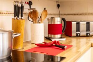 a kitchen counter with a red cutting board and utensils at Luxury Apartment - 18 Lansdown Crescent in Cheltenham