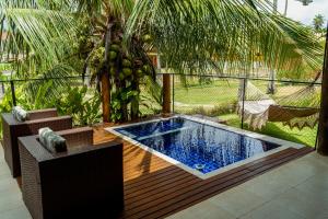 a swimming pool on a deck with a palm tree at Casa em Condomínio/ Piscina Churrasqueira privativas / Frente ao Mar / Gostoso RN in São Miguel do Gostoso