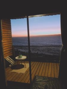 desde un porche con mesa y vistas al océano en Alojamiento Concepción, Tomé, Cocholgüe en Concepción