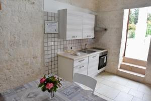 a kitchen with a sink and a table with a vase of flowers at Agape fra i Trulli Dimora Orchidea in Alberobello