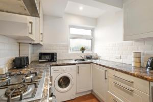 una cucina con lavatrice e asciugatrice di 50 percent off! Beautiful House - Garden - Games Room - Sleeps 9 a Plumstead