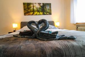 two towel swans sitting on top of a bed at Moderne FeWo SKY Netflix Terrasse Burgblick Boxspringbett Waschtrockner in Bullay