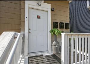 a white door on a house with a vase next to it at St Paul Fry Street Den Tower Suite #3 in Saint Paul