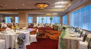 un salón de banquetes con mesas blancas y sillas blancas en Pittsburgh Marriott City Center, en Pittsburgh