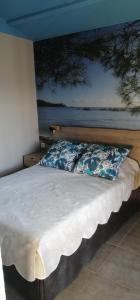 1 dormitorio con 1 cama con una pintura en la pared en Studio de charme à 300 m de la Plage de Santa Giulia en Porto Vecchio