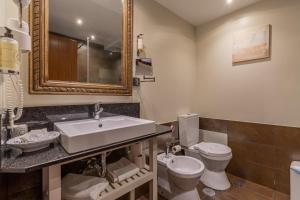 a bathroom with a sink and a toilet and a mirror at Villas D. Dinis - Charming Residence (adults only) in Lagos